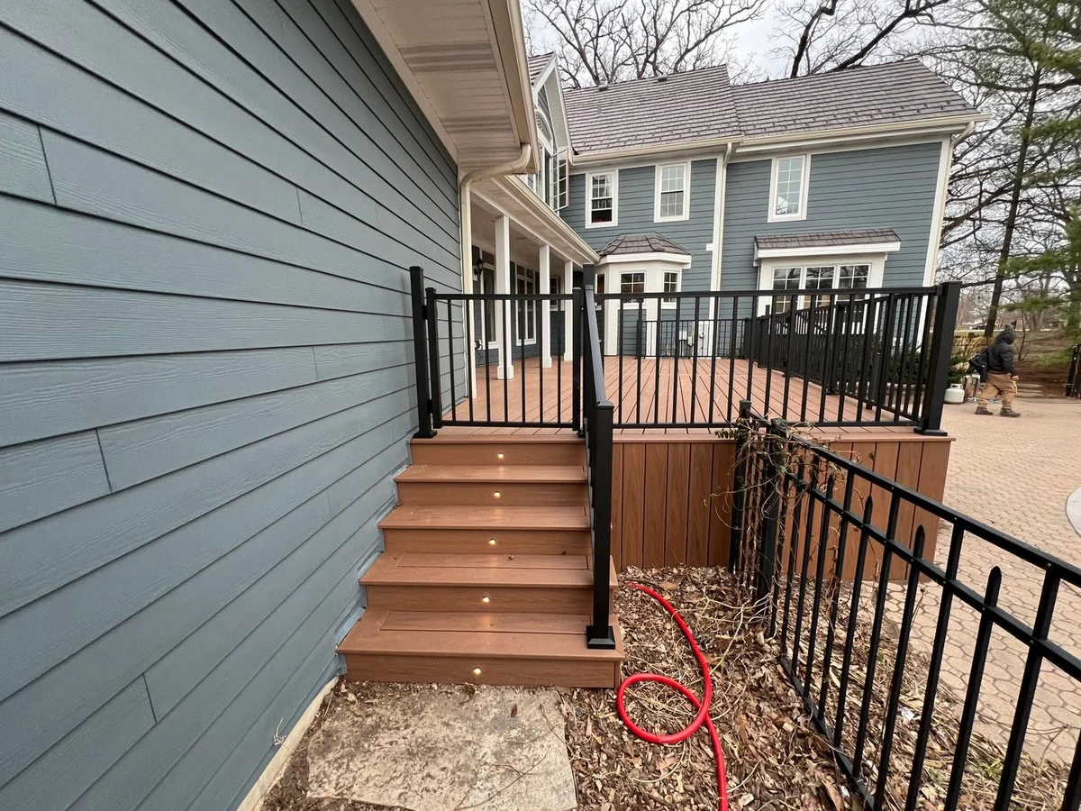 Brown deck stairs with integrated lighting and black railings