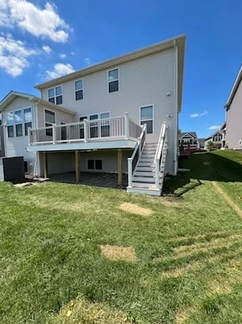 Raised deck and white staircase behind a home