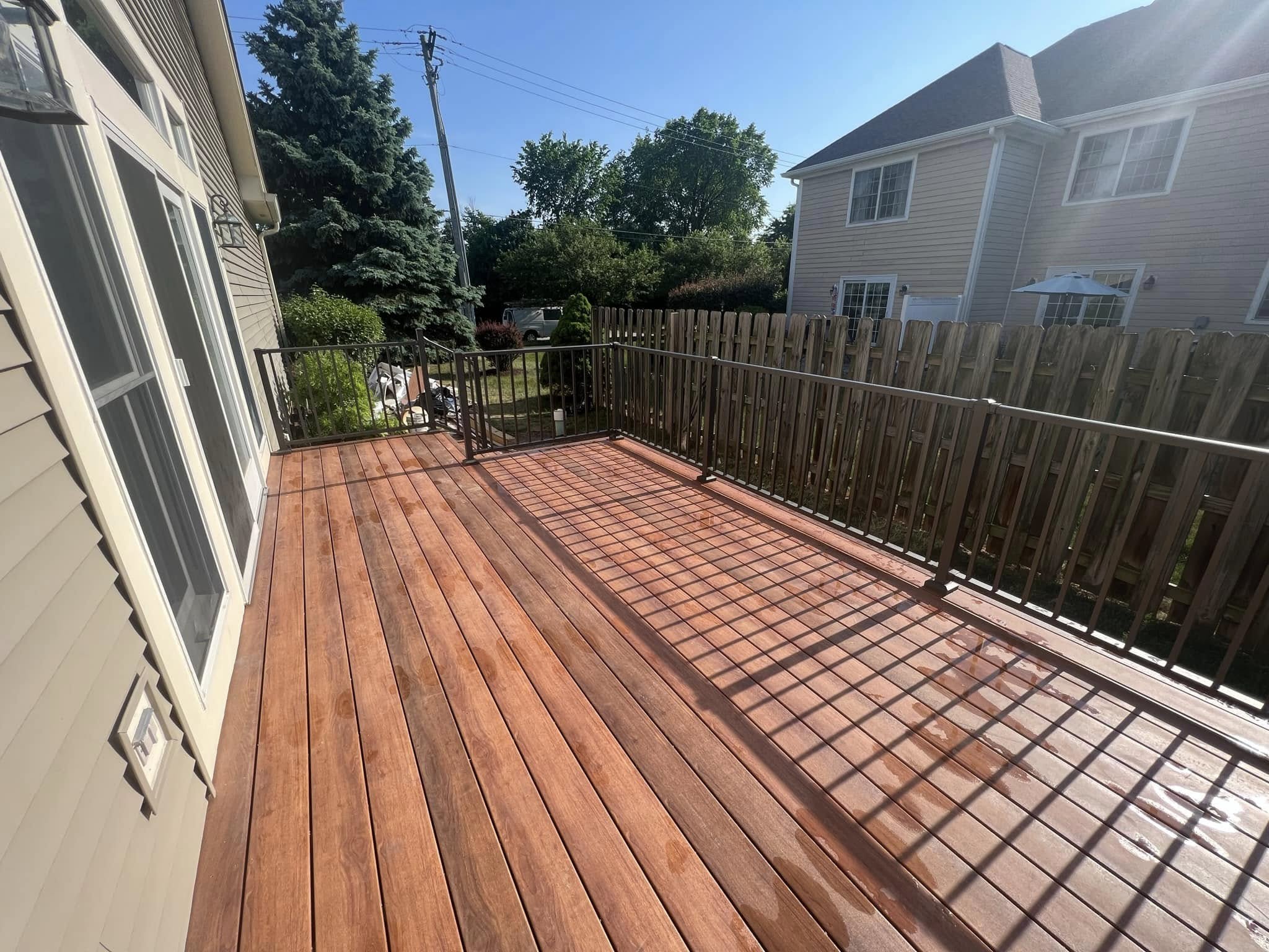 Warm brown stained deck boards and dark vertical railings at the Buffalo Grove project